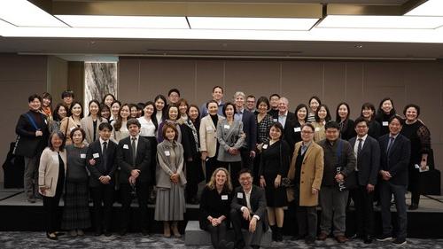 Large group of alumni smiling for photo, at a reception